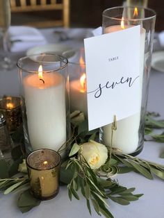 candles are sitting on a table with place cards