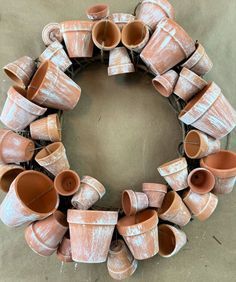 a wreath made out of clay pots sitting on the ground