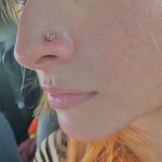 a close up of a person with a nose piercing in their left side of the face