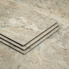 three pieces of metal sitting on top of a marble floor