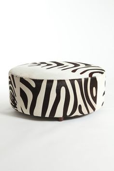 a zebra print ottoman sitting on top of a white floor