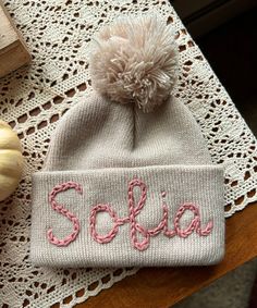 a knitted hat with the word solsia written on it next to a pumpkin