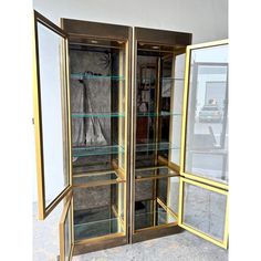 an open display case with glass doors and gold trim