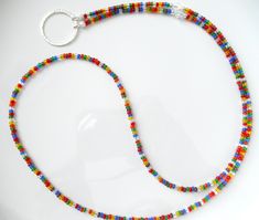 Length: Approx. 33" (to end of hammered ring) Multicolor Rainbow Eyeglass Lanyard/Sunglasses Necklace  A simple and dainty design using randomly selected smaller Czech glass beads.   You will receive one similar to the one pictured here.  It is a great length as an eyeglass necklace, or you can clip your badge onto the hammered ring if you choose.    Composition: *Swarovski crystals in Crystal AB - 6mm  *Beautiful transparent Czech glass beads (8/0) in a randomly chosen variety of fun colors *49 Glasses Necklace, Sunglasses Necklace, Eyeglass Necklace, Sunglasses Holder, Hammered Ring, Sunglass Holder, Glasses Chain, Crystal Ab, Eye Wear Glasses