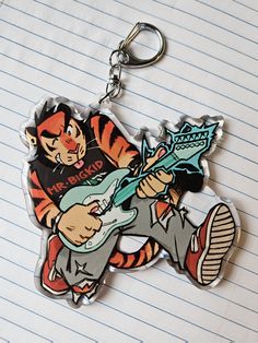 a keychain with a cartoon character holding a guitar on it's back