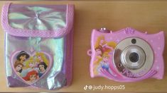 there is a pink camera next to a bag with pictures on the front and side