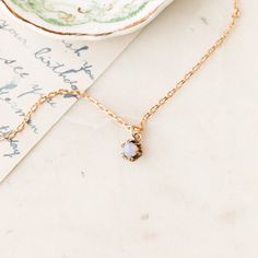 This one-of-a-kind necklace is composed of: Victorian tuxedo stud pendant from the late 1800s featuring an opal stone set in a prong setting. This necklace measures a standard 18” on a modern 14k gold filled chain. The pendant measures .25” in width.