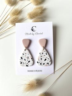 the white and black earrings are sitting on top of a card