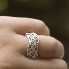 Two undulating curves define the form of this sterling silver ring which was cast from a 3d printed wax. Two layers of pattern create spatial depth and a sense of movement. Twisted ellipses march around the outer surface, while the interior one is formed by more circular cells. The ring is a part of our Cell Cycle line, created through simulations of spring meshes. Using our own software, we sculpted each design, transforming a simple mesh to a complex patterned structure. Please leave a comment with your order specifying which size you would like. item no 41 Lost Wax Casting Rings, 3d Printed Ring, 3d Tiskárna, Wax Carving Jewelry, Architectural Rings, Cast Rings, Wave Jewelry, Wax Ring, Cell Cycle