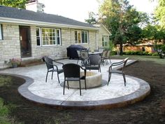 a patio with chairs and tables in front of a house