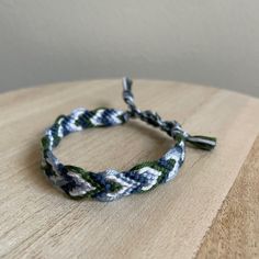 a blue and green bracelet on top of a wooden table