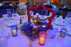 the table is set with candles, plates, and other items for an elegant dinner