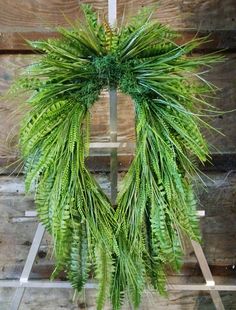 a green wreath hanging from the side of a wooden wall