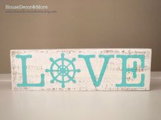 a wooden sign that says love with a ship wheel and the word love painted on it