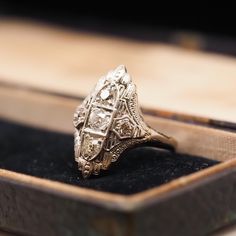 an antique diamond ring sits in a box