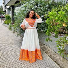 Description Embrace the warmth of the Ethiopian sunset with the simplicity and grace of the Habesha dress adorned in radiant orange hues. This elegant garment, known as the Habesha Kemis, celebrates the beauty of simplicity with its clean lines and understated design. The vibrant orange color evokes the vivid hues of an African sunset, infusing the attire with a sense of energy and vitality. Each stitch in the Ethiopian dress is a testament to the rich cultural heritage and craftsmanship of Ethi Traditional Orange Maxi Dress For Summer, Orange Tunic Dress For Festival, Orange Maxi-length Boho Dress For Festival, Traditional Orange Tunic Dress, Bohemian Orange Floor-length Dress, Orange Long Sleeve Dress For Festival, Orange Long Sleeve Festival Dress, Traditional Orange Long Sleeve Dress, Traditional Long Sleeve Orange Dress