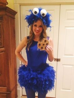 a woman in a blue dress holding a cookie