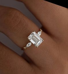 a woman's hand with a diamond ring on it and the center stone is surrounded by diamonds