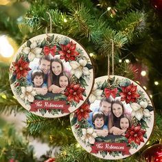 two personalized christmas ornaments hanging from a christmas tree with lights in the background and poinsettis