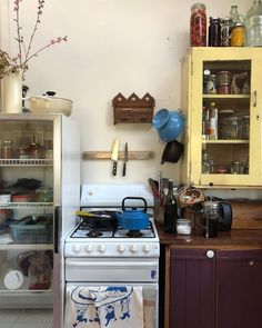 a kitchen with an oven, refrigerator and other items on the counter top in front of it