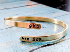 Celebrate your strength with this personalized wraparound bangle bracelet. Fashioned in brass, sterling silver, 14K gold filled, or 14K rose gold filled, this meaningful design showcases a trendy, sleek wraparound design. Complete this look with two names or phrases of your choice - each up to seven characters in length - inscribed in a tiny English and Hebrew font. FEATURES Adjustable - just slip on like a bangle bracelet and give a gentle squeeze 4.5-5mm wide Choose your wrist size and I will Adjustable Stackable Cuff Bracelet For Anniversary, Inspirational Stackable Jewelry As Gift, Meaningful Personalized Bangle Jewelry, Inspirational Stackable Jewelry As A Gift, Meaningful Adjustable Jewelry For Personalized Gift, Adjustable Bracelets For Anniversary Gift, Customizable Bangle Jewelry For Friendship, Personalized Bangle Jewelry For Friendship, Personalized Adjustable Cuff Bracelet