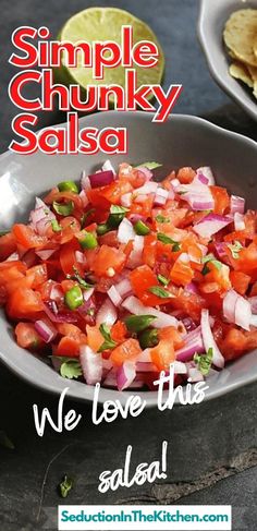 a bowl filled with salsa sitting on top of a table next to tortilla chips