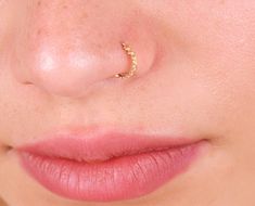 a woman's nose with a gold nose ring