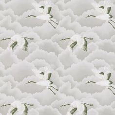 a flock of white birds flying through the cloudy sky with green leaves on it's wings