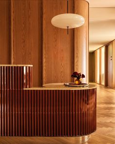 a room with wood paneling and a round light hanging from the ceiling above it