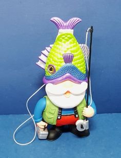 a small figurine with a fishing rod and fish on it's head