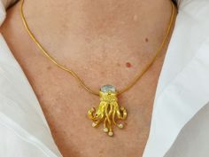 A gold jellyfish necklace with chain. The necklace is hand-crafted in sterling silver 925 and has a k18 gold plating. The gold sea-creature is decorated with an oval moonstone doublet and white cubic zirconia gemstones. The moonstone doublet reflects beautiful shades of white and blue. The jellyfish tentacles are entangled, giving the impression that the jellyfish is floating! The statement necklace has a solid lining on the back for additional comfort. The sea-jelly is handcrafted with excellen Gold Jellyfish, Jellyfish Tentacles, Jellyfish Necklace, Sea Jellies, Ocean Depth, Sea Creature, Shades Of White, Necklace Sterling Silver, Jellyfish