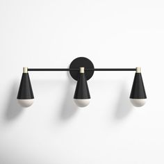 three black and white lights mounted on a wall