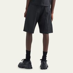 Prada bermuda shorts made of Re-Nylon, an innovative fabric made with regenerated yarn produced from plastic materials collected in the ocean Features a two-tone urban-inspired graphic print  Zip fly with hidden hook closure; belt loops High rise Angled front slash pockets Buttoned welt pockets at back Enameled metal triangle logo at side Wide legs Knee length Nylon Made in Italy Black Bermuda Shorts With Belt Loops For Summer, Nylon Shorts With Belt Loops For Summer, Nylon Bottoms With Belt Loops For Summer, Summer Nylon Shorts With Belt Loops, Modern Black Shorts With Built-in Liner, Travel Scarf, Evening Jackets, Prada Men, Triangle Logo