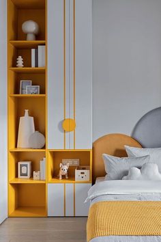 a bedroom with yellow and white decor on the shelves above the bed, along with a teddy bear