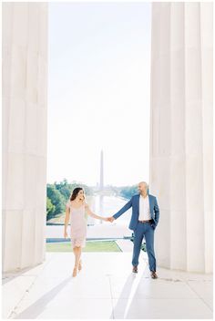 an engaged couple holding hands in front of the washington monument