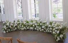 white flowers are arranged in the middle of a circular table