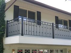 a white house with black balconies and windows