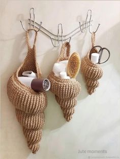 there are three baskets hanging on the wall with hair brushes and other items in them