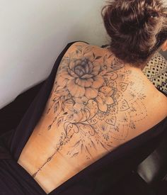 a woman with a flower tattoo on her back