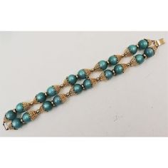 This is part of Chairish’s Costume Jewelry assortment.  1950s goldtone filigree with green resin moonglow beaded two strand bracelet with fold over clasp. Marked "Napier." Measures: 8 5/8 inches long by 15/16 inches wide. Condition: Very good; some wear to jump rings connecting two strands, otherwise great. The matching clip earrings are also available.  Please reference the measurements noted in the description above for the best approximate dimensions. Please reach out to the seller under "Ask Vintage Turquoise Round Bead Bracelets, Formal Vintage Beaded Bracelets With Round Beads, Vintage Turquoise Beaded Bracelets, Vintage Green Bracelets For Party, Vintage Beaded Bracelets For Formal Occasions, Vintage Green Beaded Bracelets, Vintage Green Round Bead Bracelets, Vintage Green Round Beads Bracelet, Moon Glow