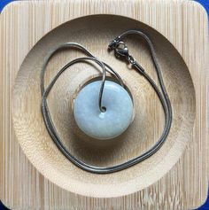 This Ping An Kou jade pendant symbolizes peace, completeness, and harmony. It is meant to bring peace and good fortune to the wearer, keeping them safe from misfortune and expressing wishes for a fulfilling life, successful career, and harmonious family. It also conveys a sense of understated elegance. 100% natural, untreated, and undyed. It's handmade with natural materials. Each piece is unique, so expect slight variations in size, color, and shape. Jade pendants have been loved since ancient Jade Amulet Necklace With Round Pendant, Round Jade Spiritual Necklaces, Jade Amulet Jewelry With Round Pendant, Spiritual Round Jade Necklaces, Spiritual Round Jade Necklace, Spiritual Jade Round Pendant Necklace, Round Jade Necklace For Spiritual Style, Jade Amulet Jewelry For Meditation, Spiritual Jade Medallion Necklace