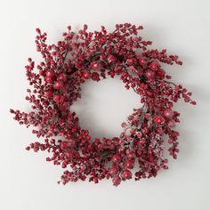 a wreath made out of red berries on a white background