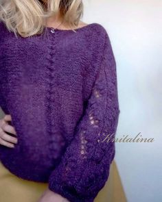 a blonde woman wearing a purple sweater posing for the camera with her hands on her hips