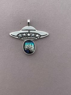 Beautiful shimmering dichroic glass in this unique UFO pendant made in sterling silver. Add this tiny treasure to your collection or makes a great gift for UFO Enthusiast. It is my passion to make one of a kind jewelry by hand, thank you for supporting my small business, it means the world! Ufo Jewelry, Lake Havasu City, Lake Havasu, Tiny Treasures, Dichroic Glass, Belt Buckles, Pendant Necklaces, Turquoise Ring, Turquoise Necklace