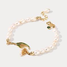 This exquisite Lily Of The Valley Pearl Bracelet is sure to add a touch of sophistication to any ensemble. Crafted with the finest enamel and pearls, its classic design makes it the perfect addition for any occasion. Timeless and elegant, it will be sure to turn heads.  >> See   More  Lily of the Valley   Jewelry   Collection. DETAILS Materials:   18K Gold on brass, Enamel, Freshwater Measurements: Length: 6.10"(15.5cm) + Extender: 2.36"(6.0cm) Weight:  9.91g Note: It will be in stock in 10-15 b Elegant White Bracelet As A Gift, Elegant White Bracelet Suitable For Gifts, Green Pearl Charm Jewelry For Wedding, Wedding Pearl Charm Bracelet, Elegant Green Gold Bracelet For Wedding, Gold Flower Charm Bracelet For Weddings, Gold Flower Pearl Bracelet For Wedding, Dainty Green Bracelets For Wedding, White Gold Bracelet With Pearl Charm For Wedding