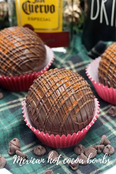 three chocolate cupcakes sitting on top of a green and white checkered table cloth