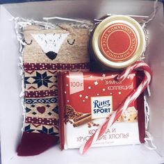 an assortment of items in a gift box with candy canes and other holiday treats