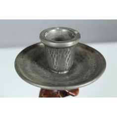 a silver cup and saucer sitting on top of a plate