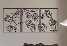 three metal wall art pieces with flowers on them