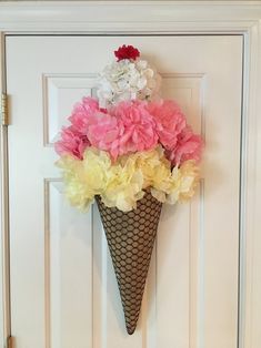 an ice cream cone decorated with flowers hangs on the front door